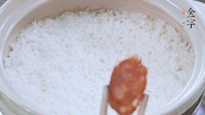 煮開后轉(zhuǎn)小火，當(dāng)米飯出現(xiàn)小孔時(shí)，鋪上金字麻辣香腸。