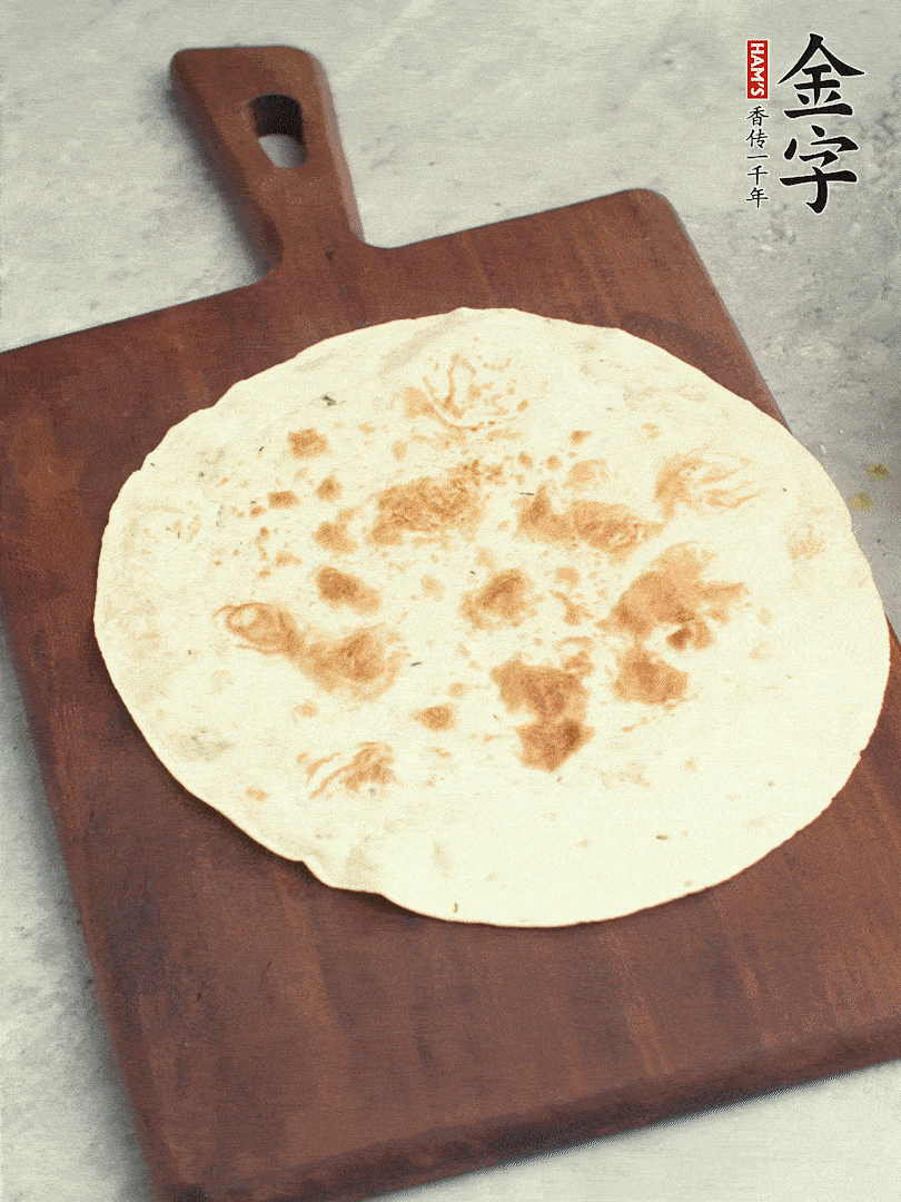 食材依次鋪在卷餅皮上，卷起來。