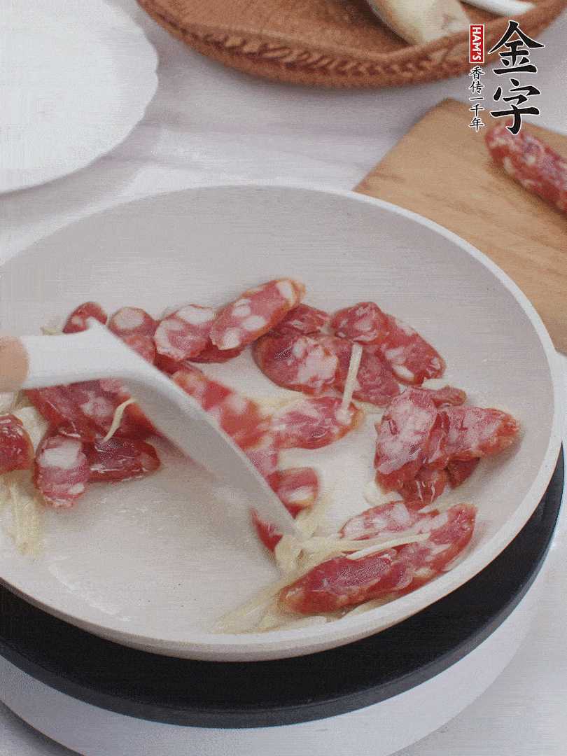 油溫3成熱時，下姜絲、蒜片、香腸炒出油脂。