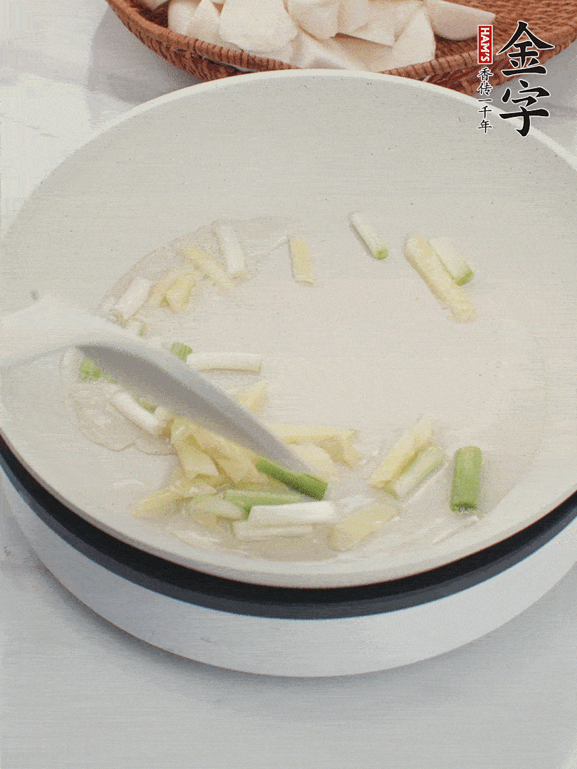 鍋中油五成熱，下蔥白、姜片爆香。