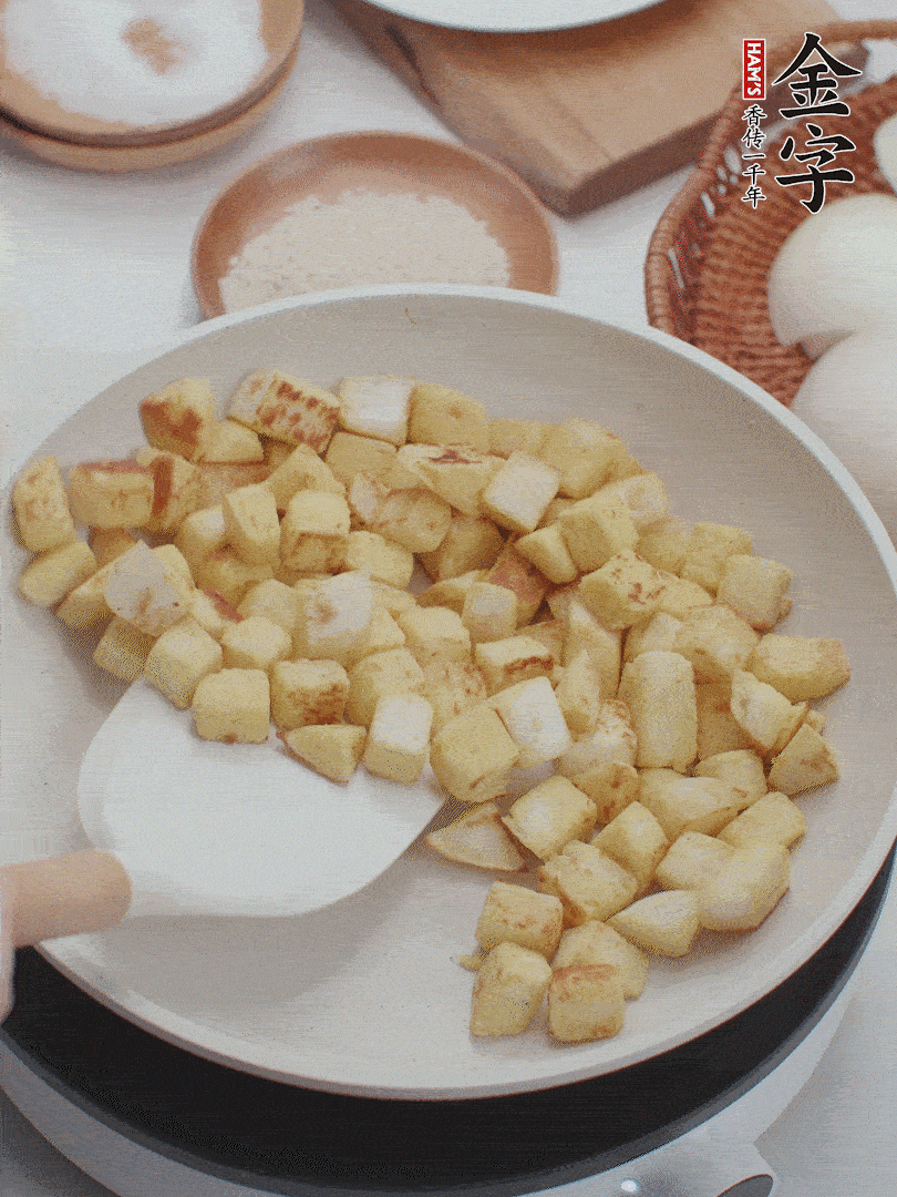 起鍋熱油，倒入饅頭丁，小火煎至蛋液凝固定型再翻面，饅頭丁部煎至金黃時盛起待用。