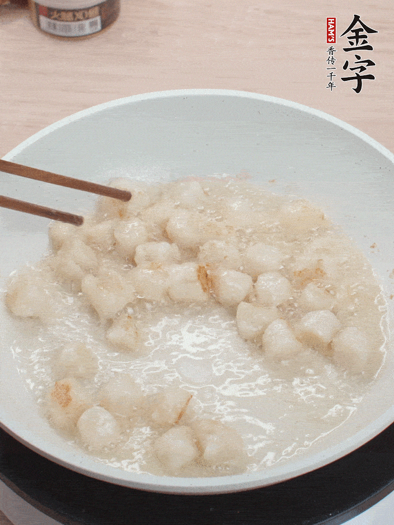 油溫4成熱，鮮貝蘸干淀粉下鍋煎，一面微黃后翻面。