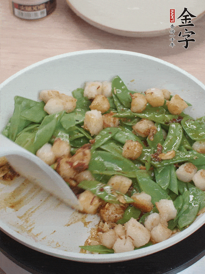 下甜豆莢、鮮貝輕輕翻炒均勻。