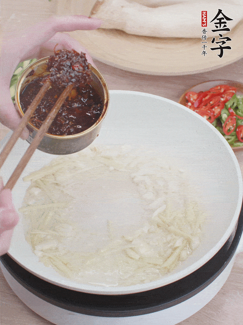 起鍋熱油，姜蒜、金字火腿干貝醬煸香。