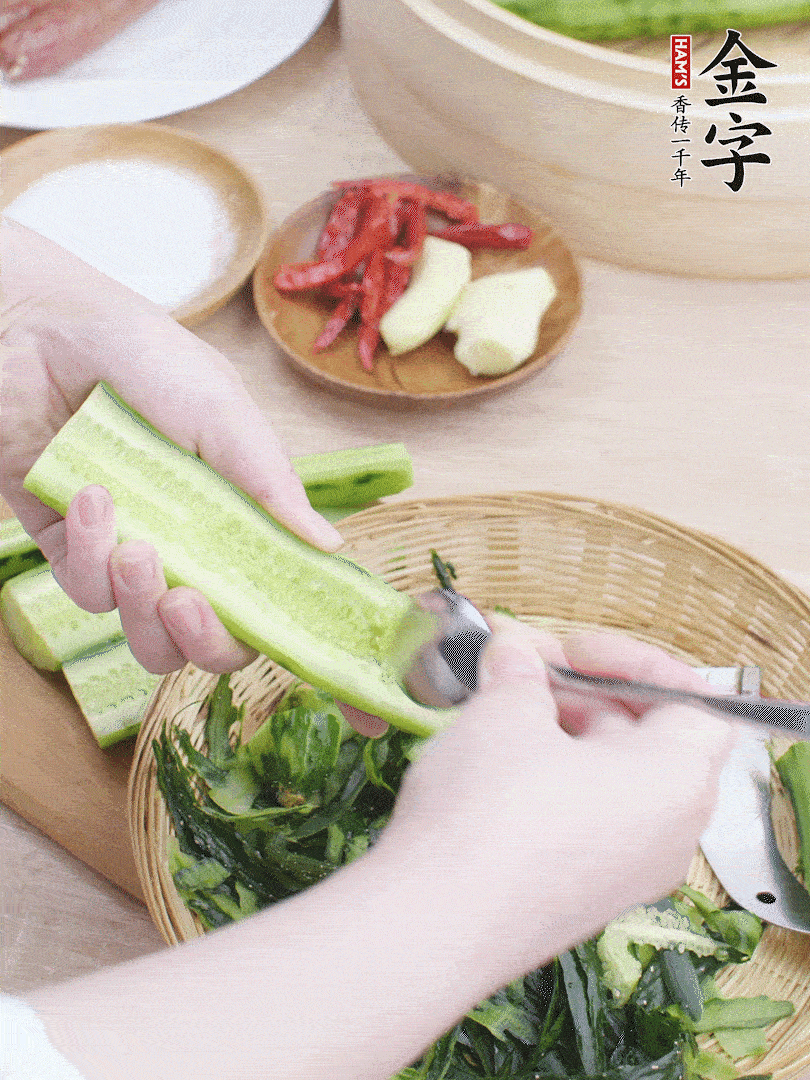 黃瓜削皮，對(duì)半切開(kāi)，勺子挖去內(nèi)瓤，斜刀切片。青蒜斜刀切段。