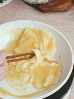 油6成熱時(shí)，下雞蛋液，邊緣凝固時(shí)翻拌成塊狀。