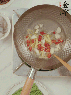 油7成熱時(shí)，下大蒜粒、姜絲、小米辣煸香。