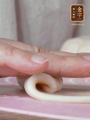 做面劑 油皮按扁，中間包入一個油酥，邊緣收緊捏死。包好的面劑按扁，用搟面杖搟壓成橢圓形。從底部向上卷成筒狀，用保鮮膜蓋好松弛15分鐘，再把筒狀縱向搟壓成長條狀。再卷一次，松弛20分鐘