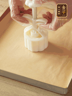 取一個面團，捏扁，中間厚，四周薄。虎口往上推，直到收口，把餅胚放入模具里，壓2-3下