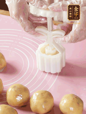 收緊虎口搓圓，裹上一層面粉，放入模具壓一壓