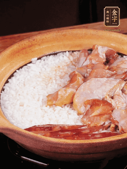 煮到椰子水微微收干轉(zhuǎn)小火，快速均勻鋪上雞肉、金字香腸