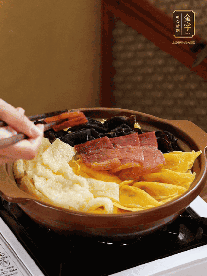 砂鍋底部鋪上娃娃菜，依次擺上肉皮、蛋餃、黑木耳、火腿